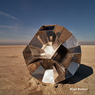 Geometric metallic sculpture in a desert landscape with clear blue sky