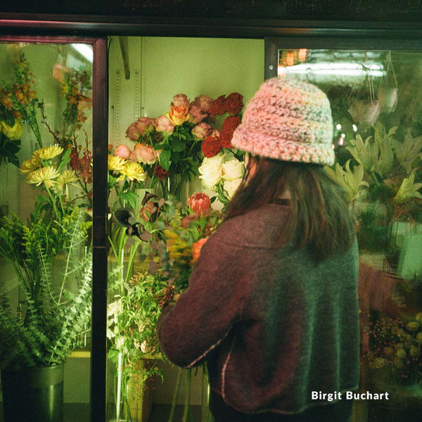 Person wearing a knit hat looking at flowers in a store