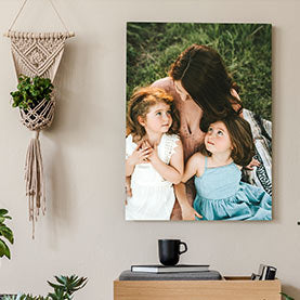 a mother and her two daughters portrait on canvas hanging in a living room