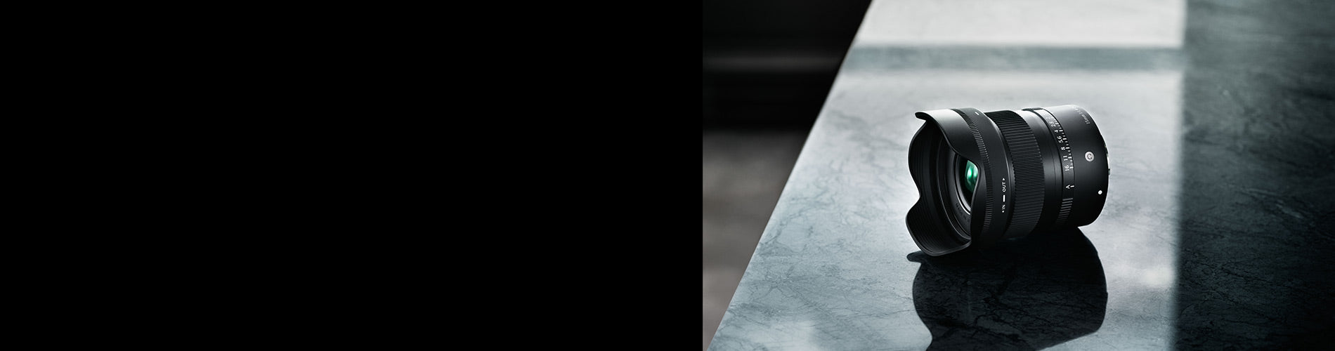 Camera lens on a reflective surface with a dark background