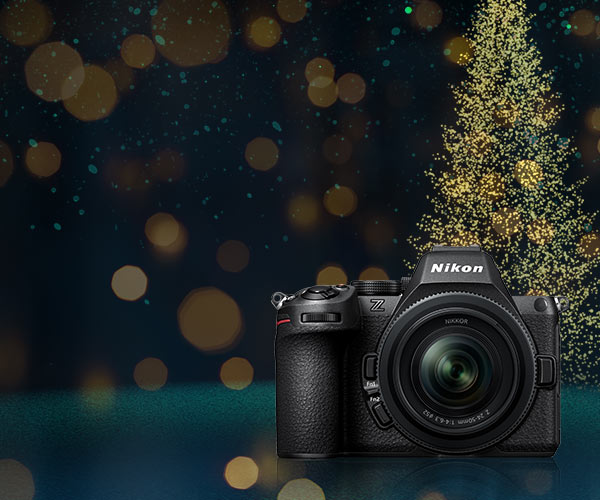 Nikon camera with a festive background featuring a Christmas tree.