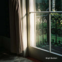 Window with decorative iron grille and light filtering through, with 'Birgit Buchart' credit.
