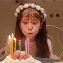 young girl blowing out birthday candles on a cake