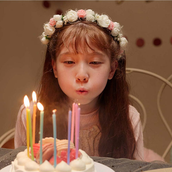 young girl blowing out birthday candles on a cake