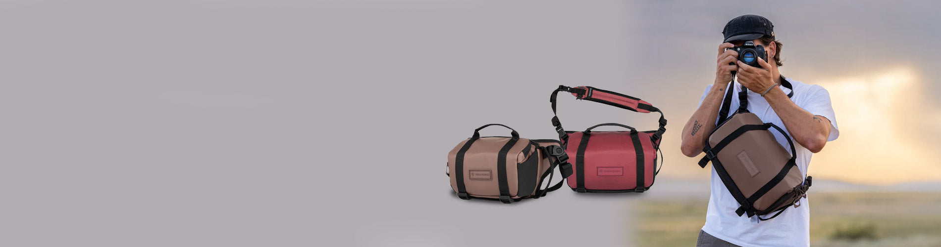 Two Wandrd camera bags displayed side by side with a person holding one of them outdoors.