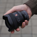 Sony FE 14mm 1.8 GM Lens held in someone's hand